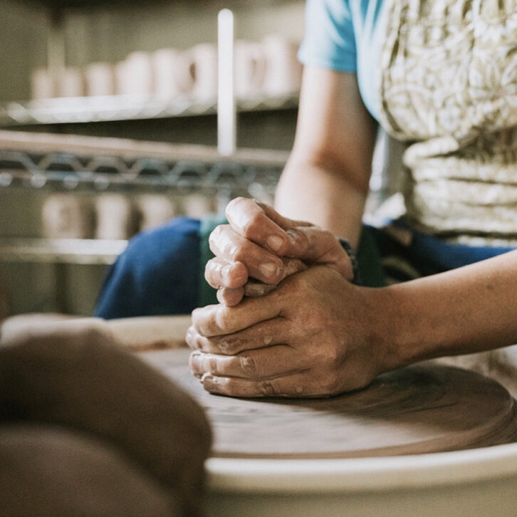 Jennifer Adamson, owner of Kiln To Table, at the wheel creating her signature mugs.