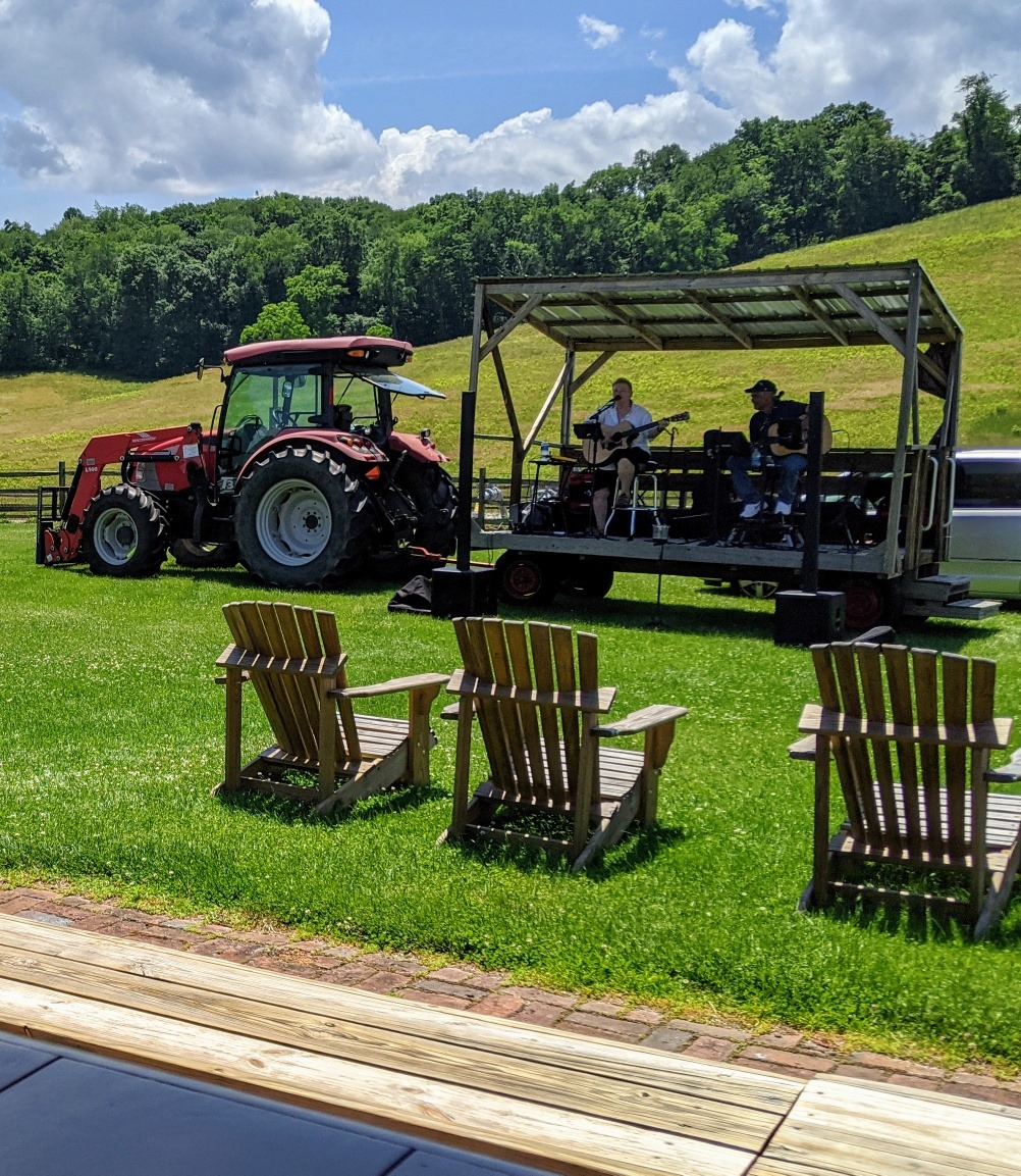 Photograph of tractor with musicians on a stage at Thistlethwaite Vineyards.