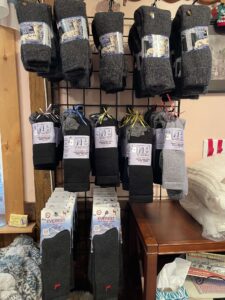 Photograph of a vertical rack display of thermal gray socks at Lippencott Alpacas.