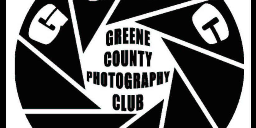 Black-and-white logo for the Greene County Photography Club, designed as a camera shutter with ‘GCPC’ around the edge and the club name in the center