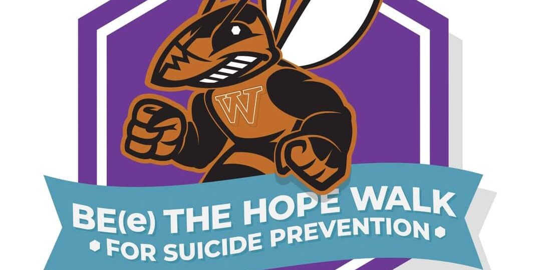 The image is a logo for the "Be(e) the Hope Walk" suicide prevention event. It features the mascot of Waynesburg University, a muscular Yellow Jacket with a "W" on its chest, symbolizing strength and resilience. The Yellow Jacket is set against a purple hexagonal background with a light blue banner below that reads, "Be(e) The Hope Walk for Suicide Prevention."