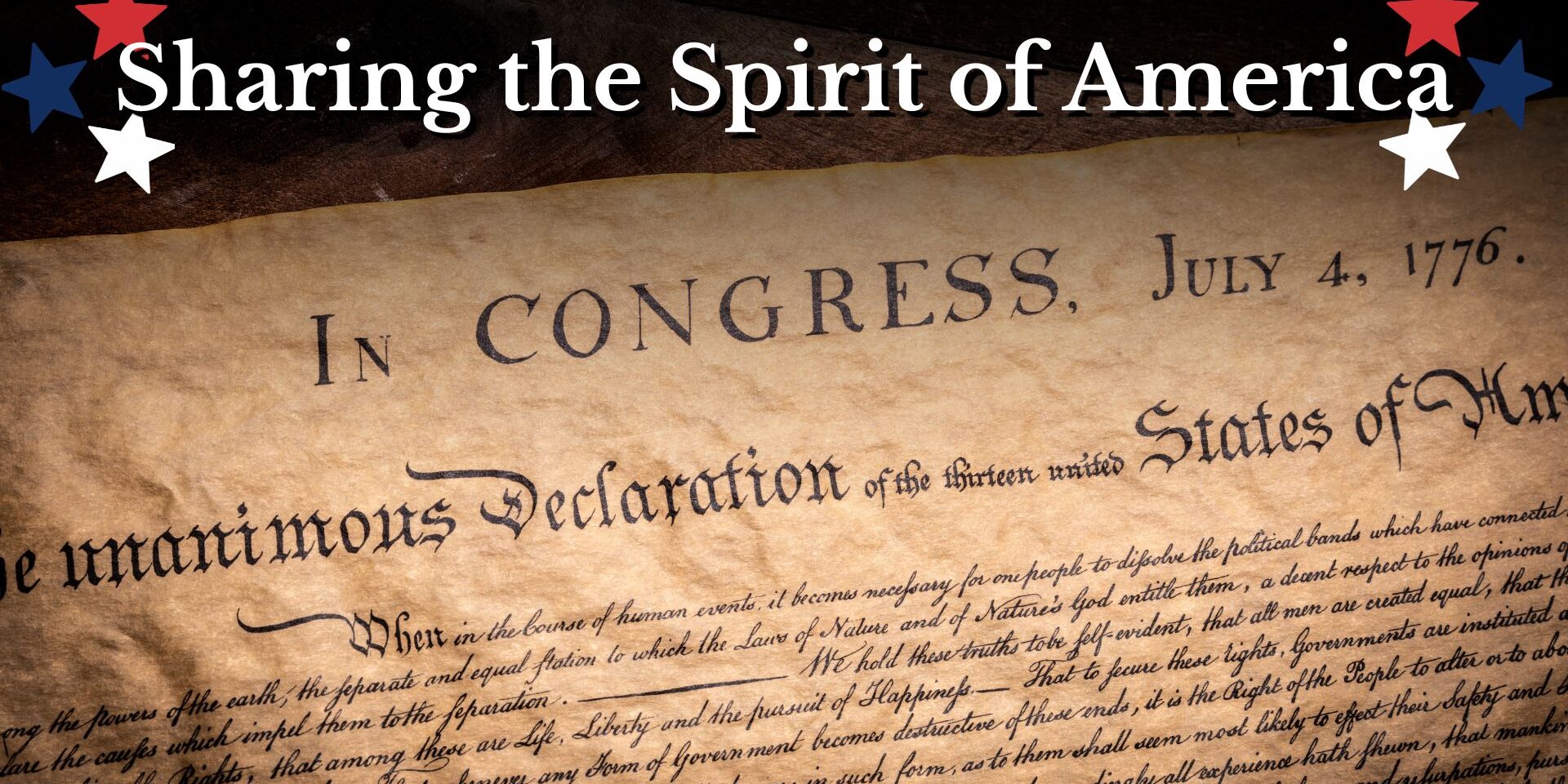 Sharing the Spirit of America Patriotic banner graphic featuring the words “Sharing the Spirit of America” above a close-up image of the United States Declaration of Independence manuscript. Red, white, and blue stars decorate the corners, with visible text from the historic document against a parchment-style background.